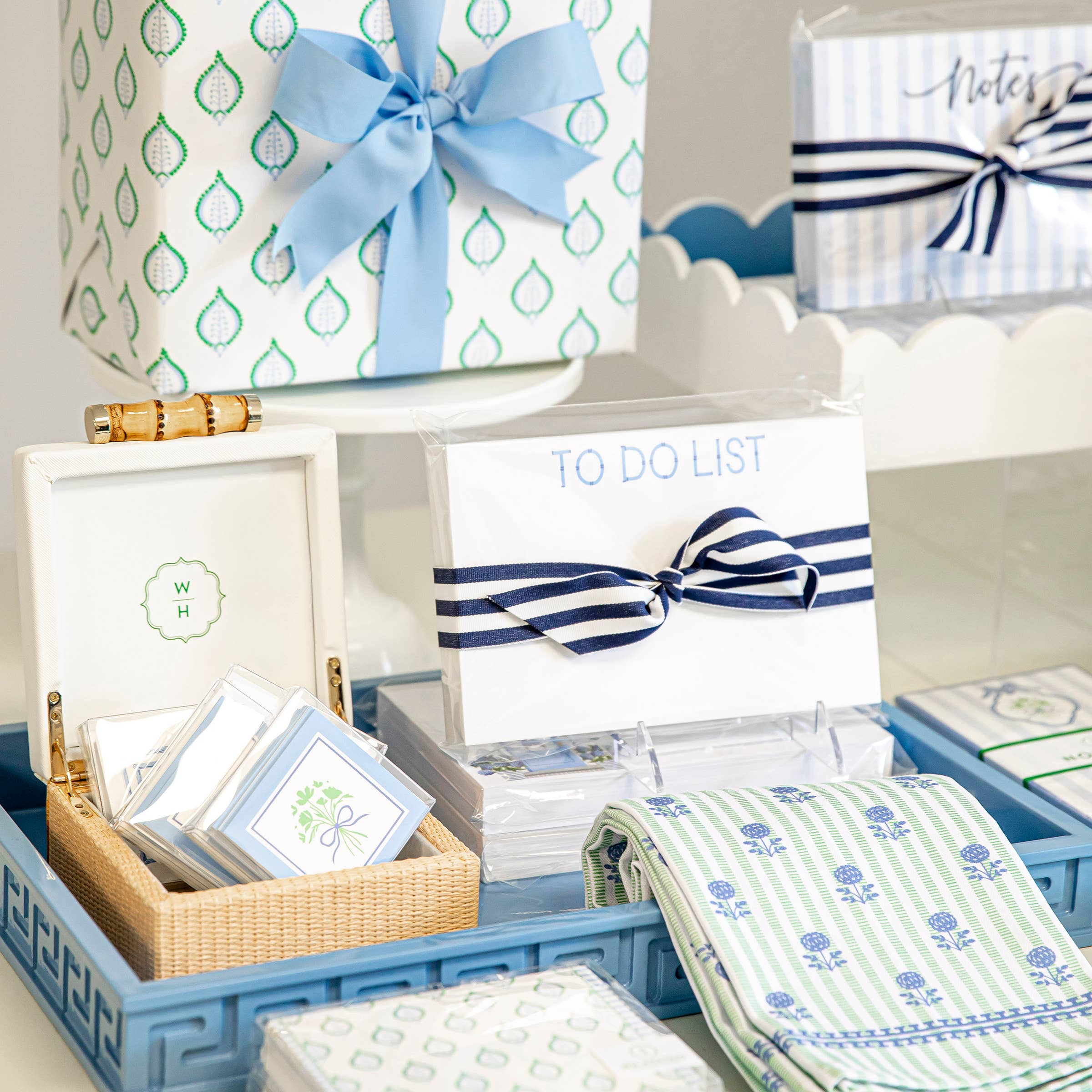Organized stationery items with blue and white ribbons in a decorative box.