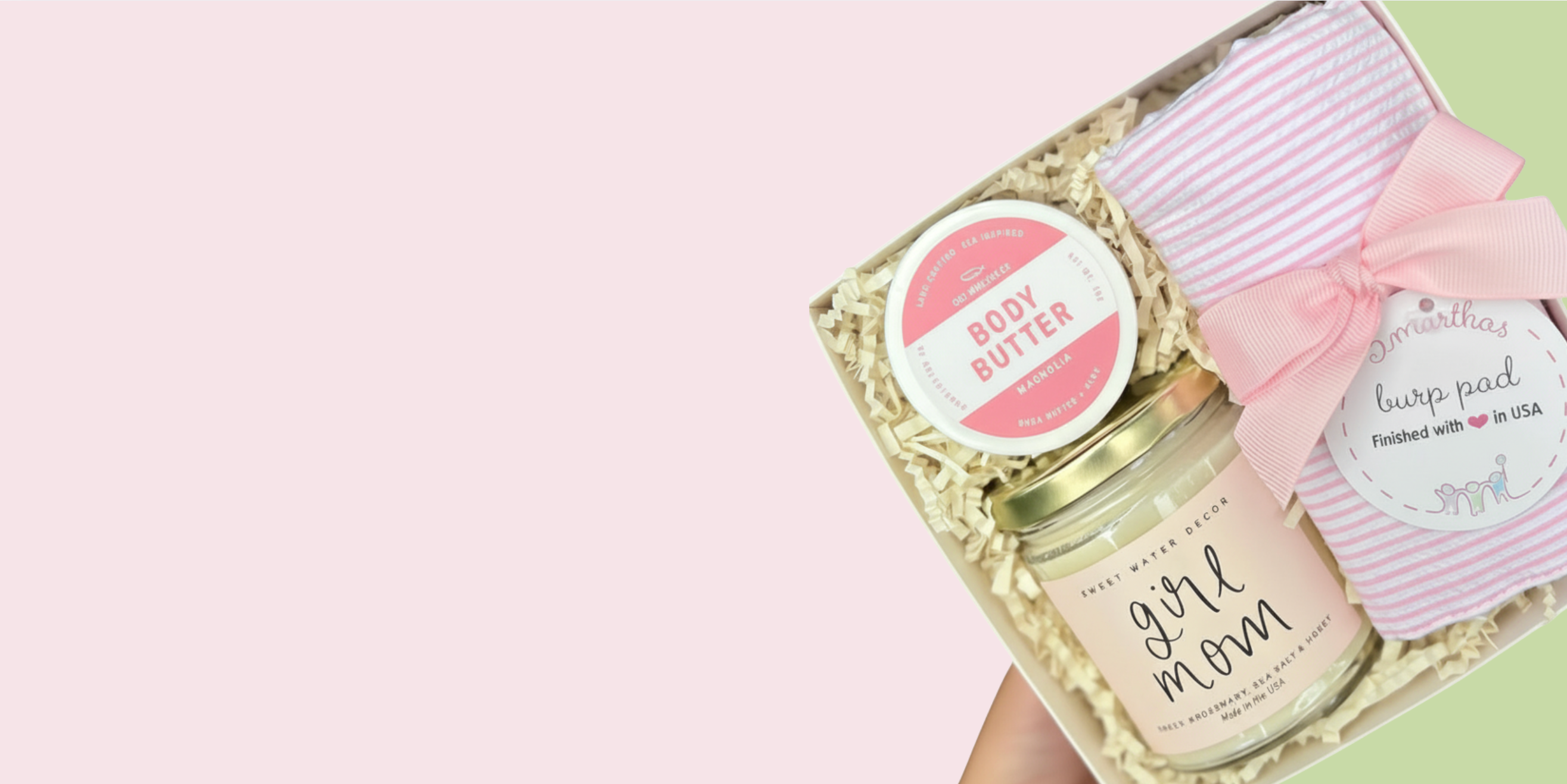 Gift set with 'Girl Mom' body balm and a towel on a light pink background