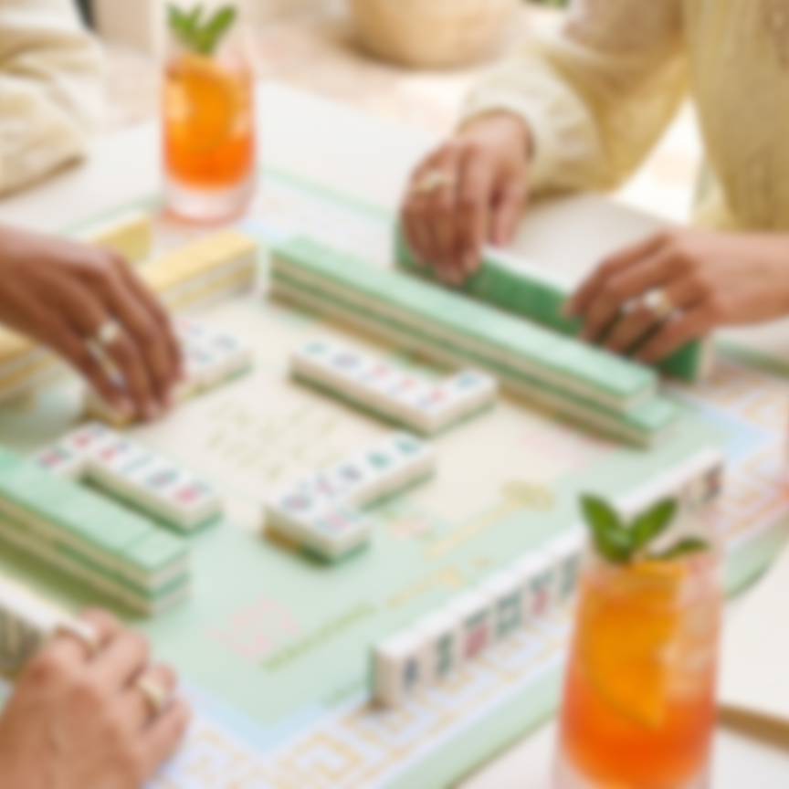 People playing a board game with drinks on a table